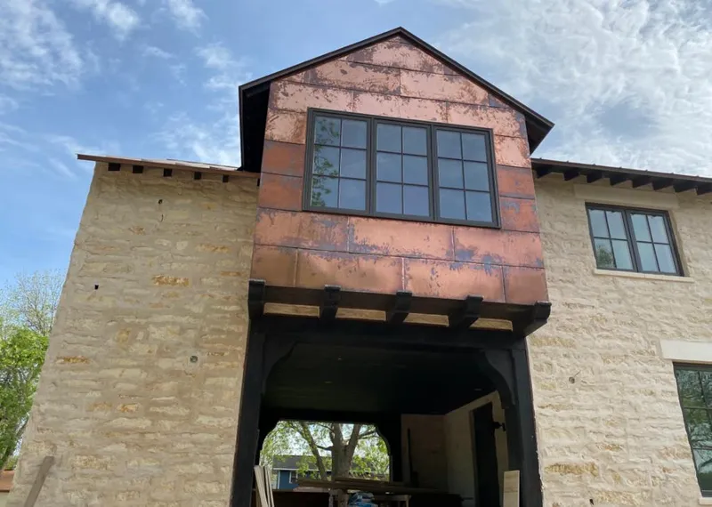 Copper metal panel facade on a stone building for Roof Repair in Nolanville